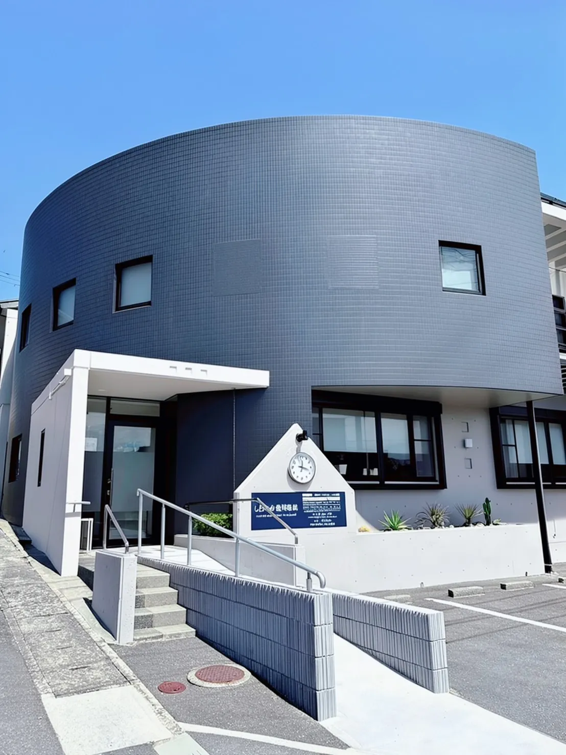 しらなみ歯科医院の外観。紺色の曲面が印象的な建物